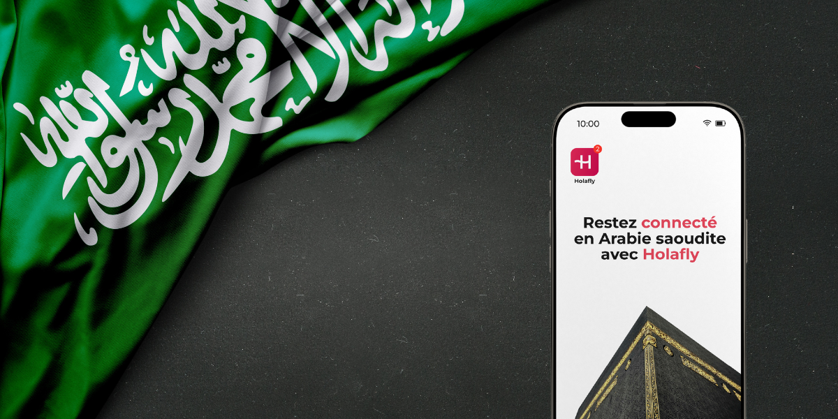 Image publicitaire montrant un smartphone avec l'application Holafly affichant 'Restez connecté en Arabie saoudite' sur un fond noir texturé, à côté du drapeau saoudien et d'un visuel de la Kaaba, illustrant la facilité de connexion pour les pèlerins.