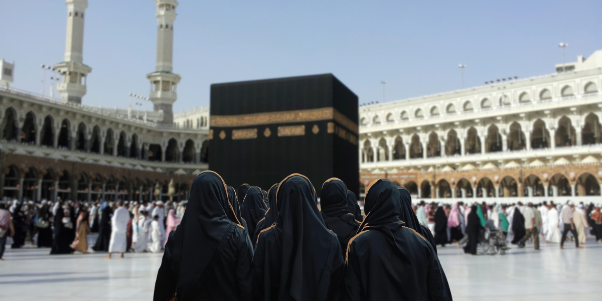 Groupe de femmes pèlerines devant la Kaaba, illustrant les voyages en groupe mixte ou composé uniquement de femmes lors de la omra sans Mahram.