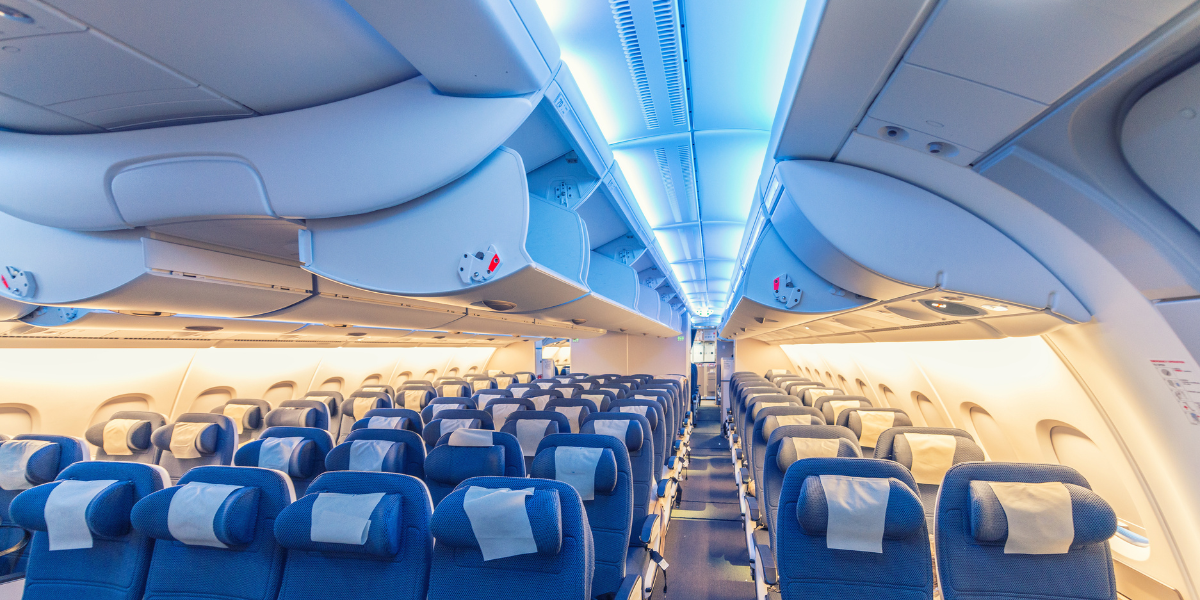 Vue de l'intérieur de la cabine d'un avion, illustrant le confort de voyage pour les pèlerins en transit vers l'Arabie Saoudite pour leur Omra.