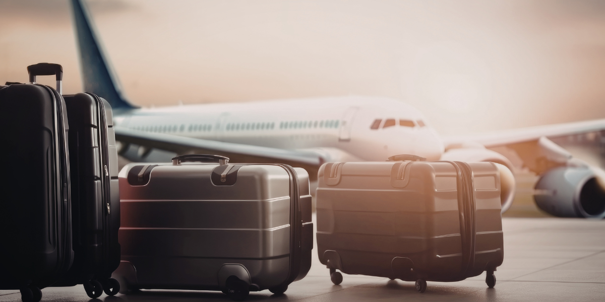 Plusieurs valises alignées sur le tarmac devant un avion, illustrant la franchise bagage généreuse et la sérénité d'un vol avec Royal Jordanian.