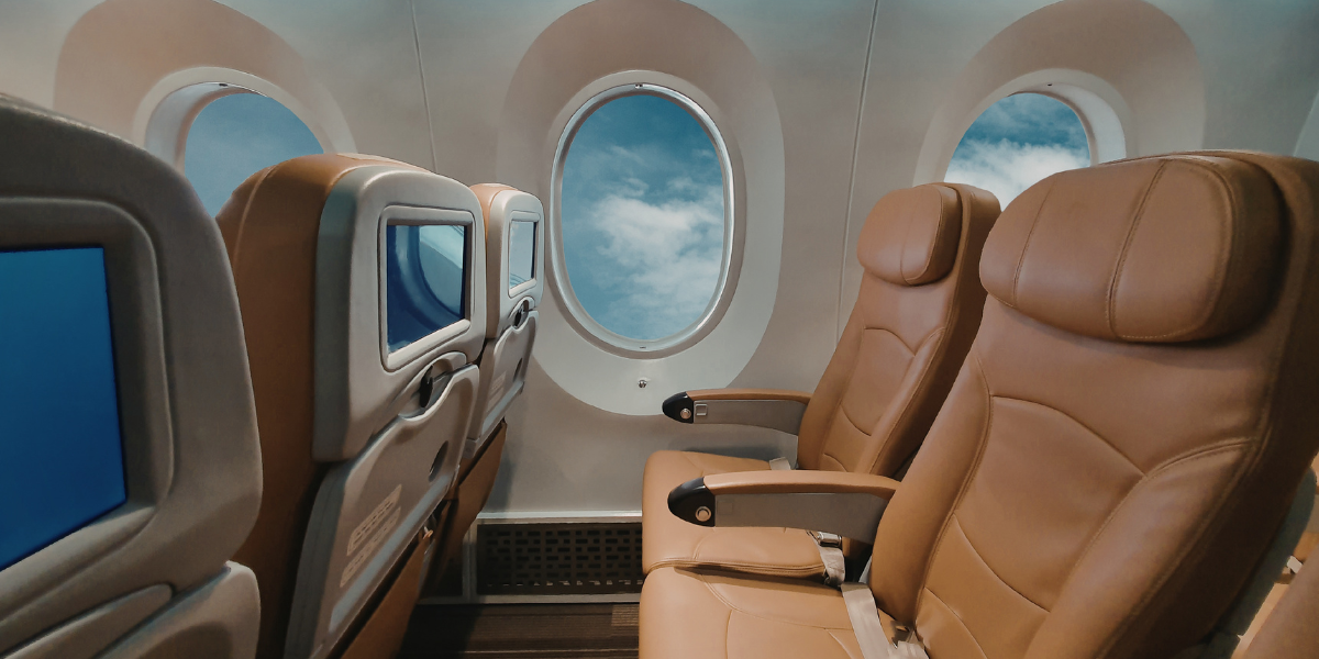 Vue de l'intérieur de la cabine passagers d'un avion, illustrant le confort et les services dédiés durant le vol Saudia Airline vers la Omra.