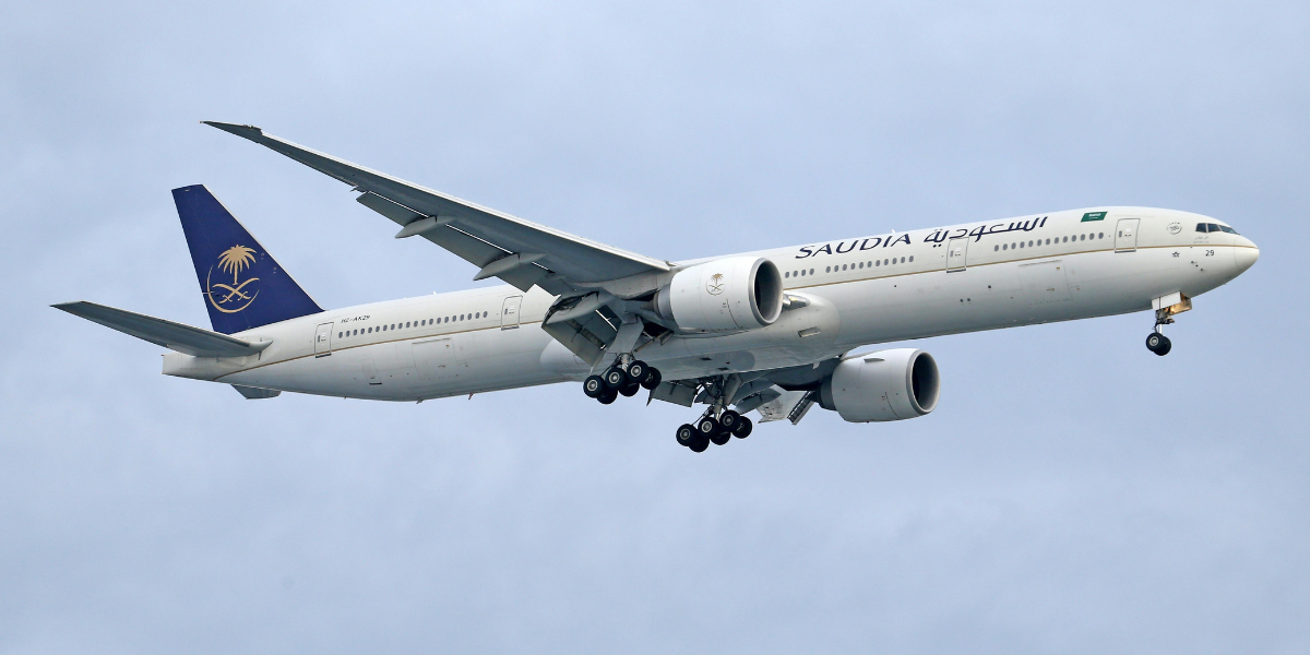 Avion de la compagnie Saudia Airlines en vol, illustrant le transport aérien pour la Omra au départ de Lyon.