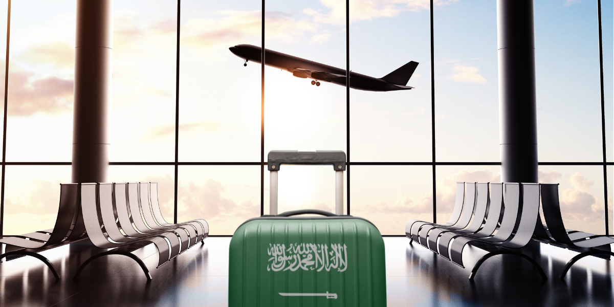 Valise avec le drapeau de l'Arabie saoudite dans un aéroport, illustrant la gestion et le transport des bagages pour la Omra avec Saudia Airlines.