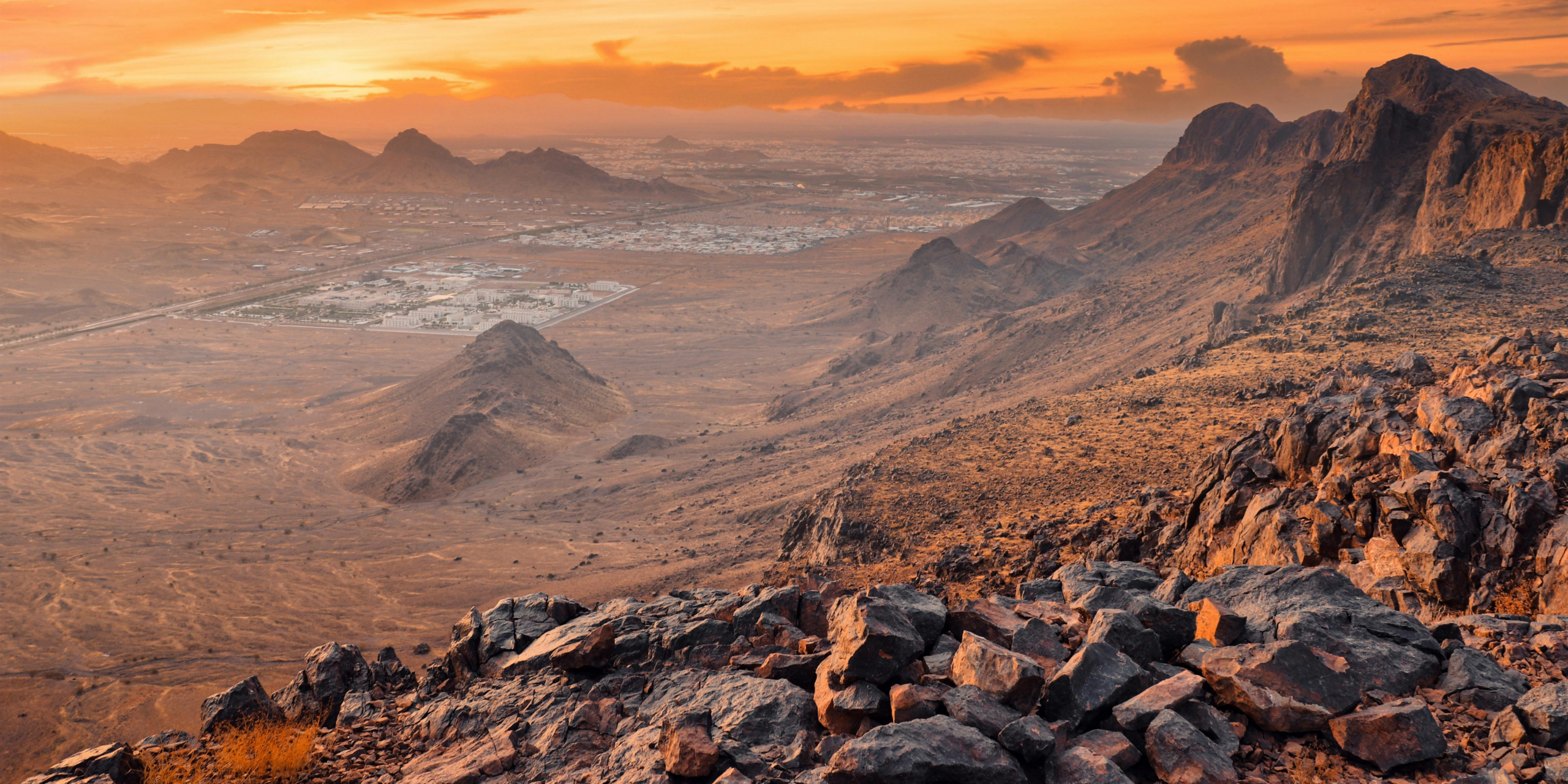 Vue sur les montagnes rocheuses du mont Uhud à Médine sous un ciel clair, illustrant la découverte des sites historiques et des Ziyarat à son propre rythme avec un guide privé lors d'une Omra en solo.