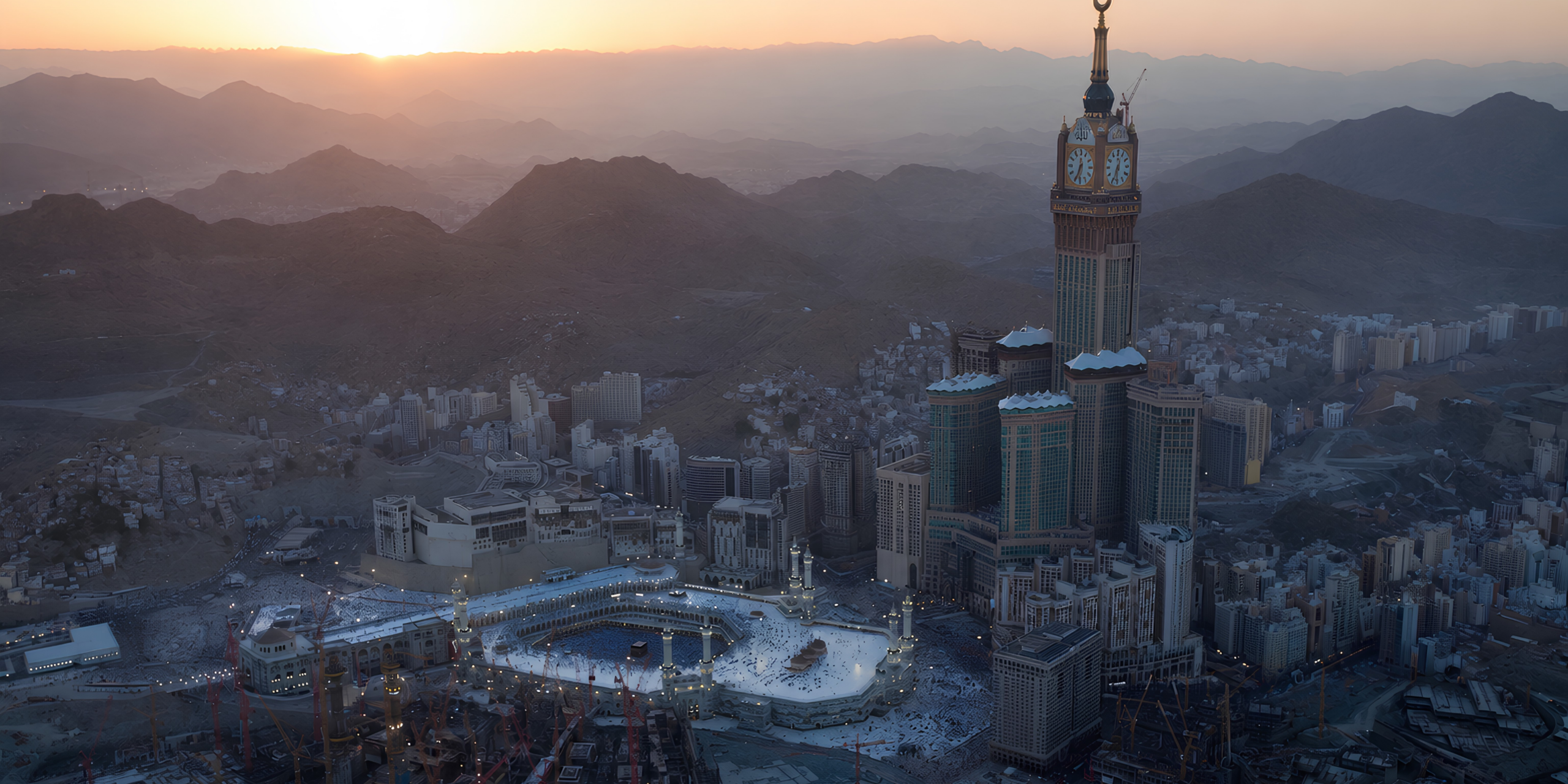 Splendide vue aérienne de la ville de La Mecque au coucher du soleil, mettant en valeur la Makkah Clock Tower, la Grande Mosquée illuminée et les complexes hôteliers environnants, pour illustrer les avantages d'une Omra personnalisée et sans contrainte de groupe.