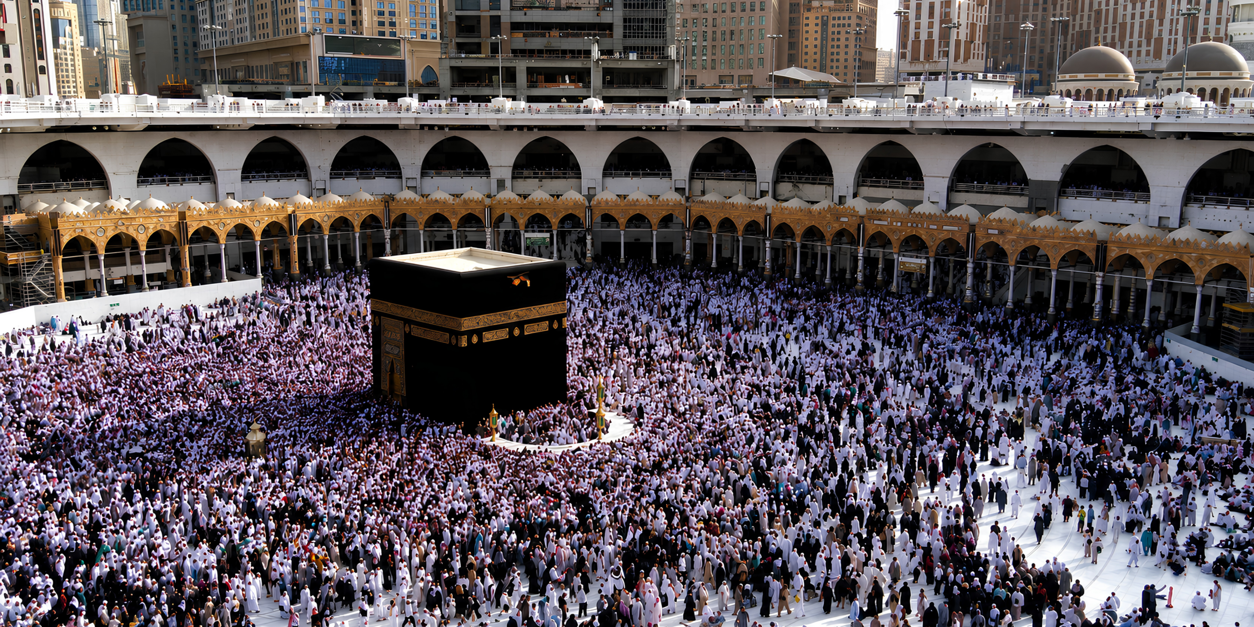 Une vue en plongée de la cour de la Mosquée sacrée à La Mecque entourant la Kaaba, montrant une foule diversifiée de pèlerins, idéale pour illustrer les questions de logistique familiale, de règles de voyage et de durée de séjour avec Direct Mecca.