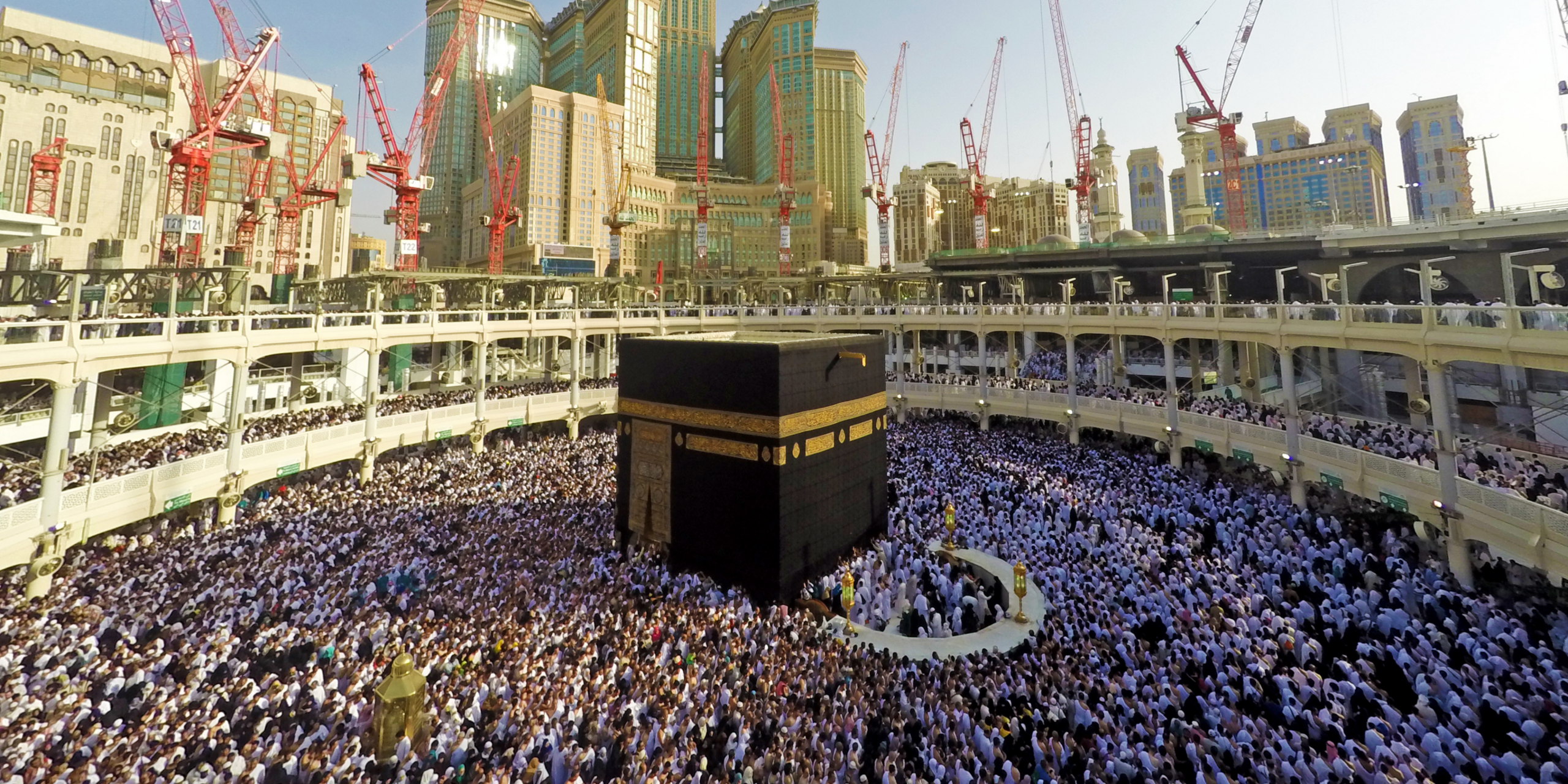Vue panoramique sur la Kaaba entourée de pèlerins au cœur de la Mosquée sacrée à La Mecque, illustrant la gestion logistique et la sécurité lors d'une première Omra avec guide.