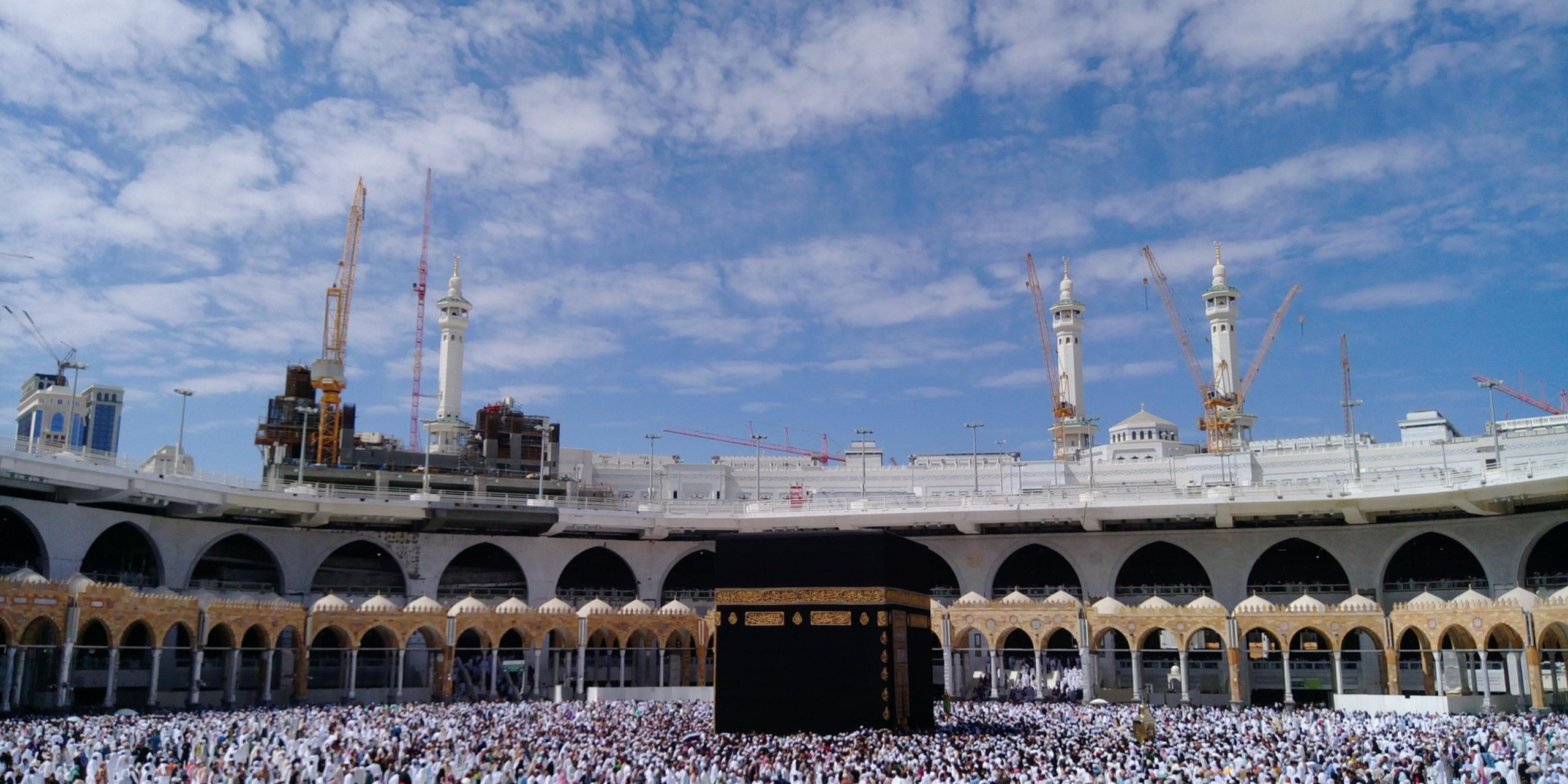 Des milliers de pèlerins réunis en prière autour de la Kaaba, illustrant l'accompagnement éthique et sur mesure de Direct Mecca pour un voyage spirituel en toute sérénité.