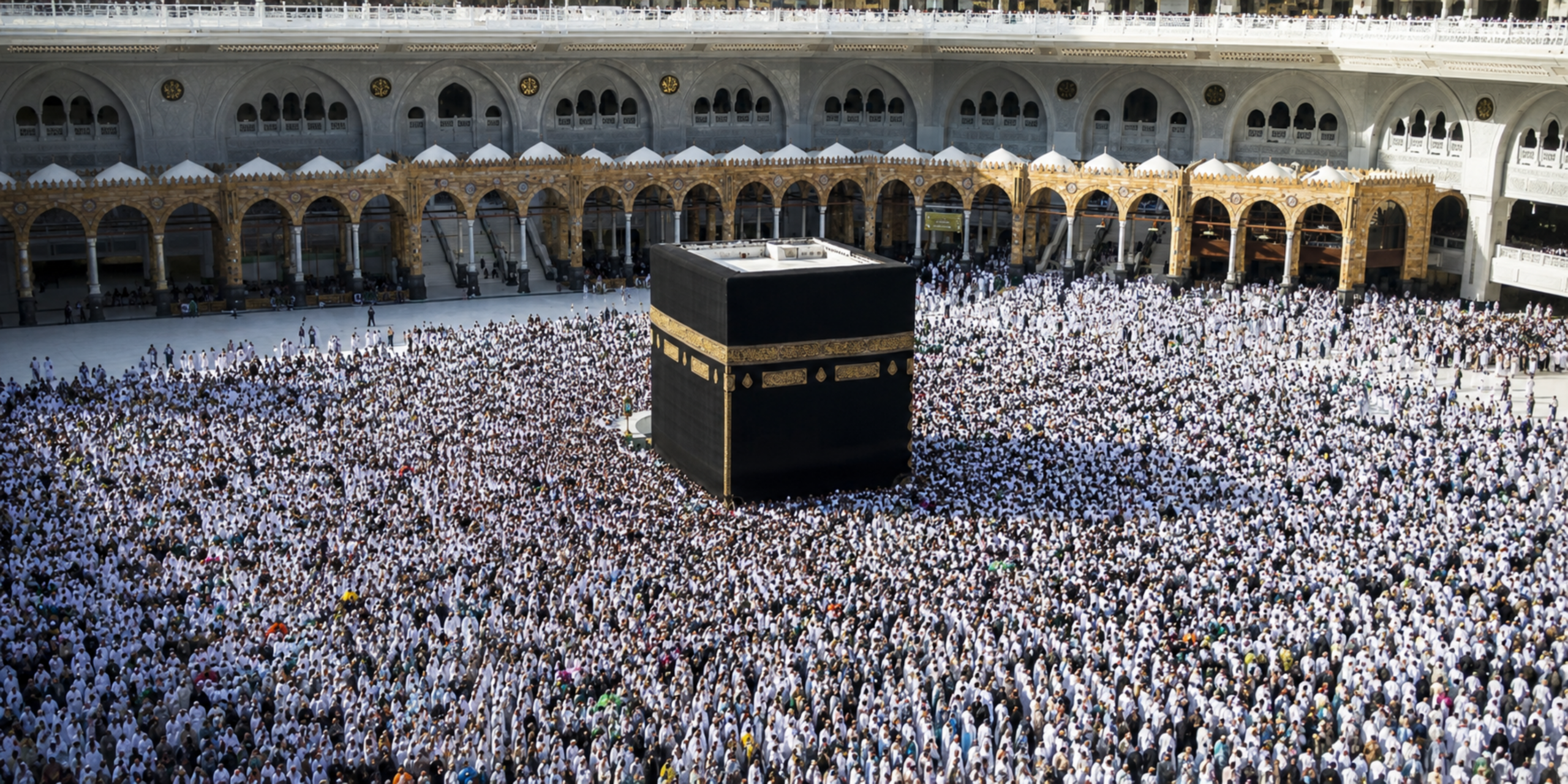Une vue aérienne plongeante sur la Kaaba entourée par une immense foule de pèlerins accomplissant le Tawaf sur l'esplanade de la Mosquée Al-Haram, illustrant l'importance d'un accompagnement pour comprendre et réaliser chaque rite en direct.