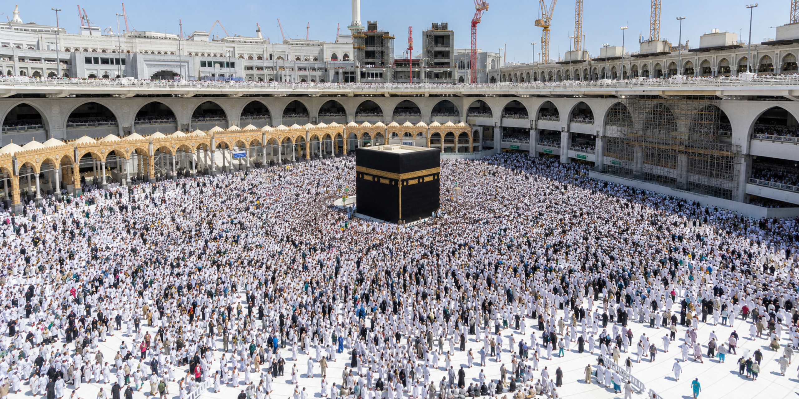 Une vue plongeante sur l'esplanade blanche de la Grande Mosquée de La Mecque avec la Kaaba au centre, entourée d'une multitude de pèlerins en habit d'Ihram blanc, illustrant le rôle clé d'un guide pour s'orienter et accomplir sereinement les rites lors d'un séjour encadré.