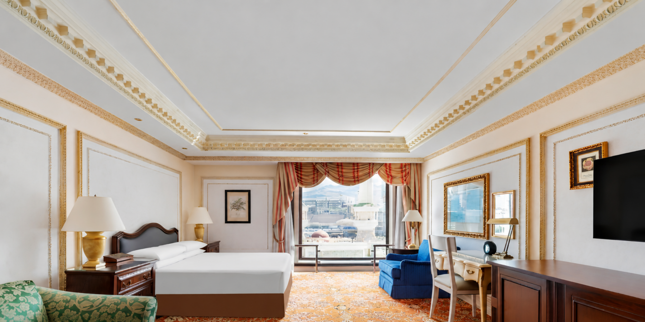 Une chambre de luxe élégante avec moulures dorées, grand lit double et coin bureau, offrant une vue sur le Masjid Al-Haram à travers la fenêtre, illustrant les tarifs et les prestations de l'hôtel Dar Al Tawhid à La Mecque.