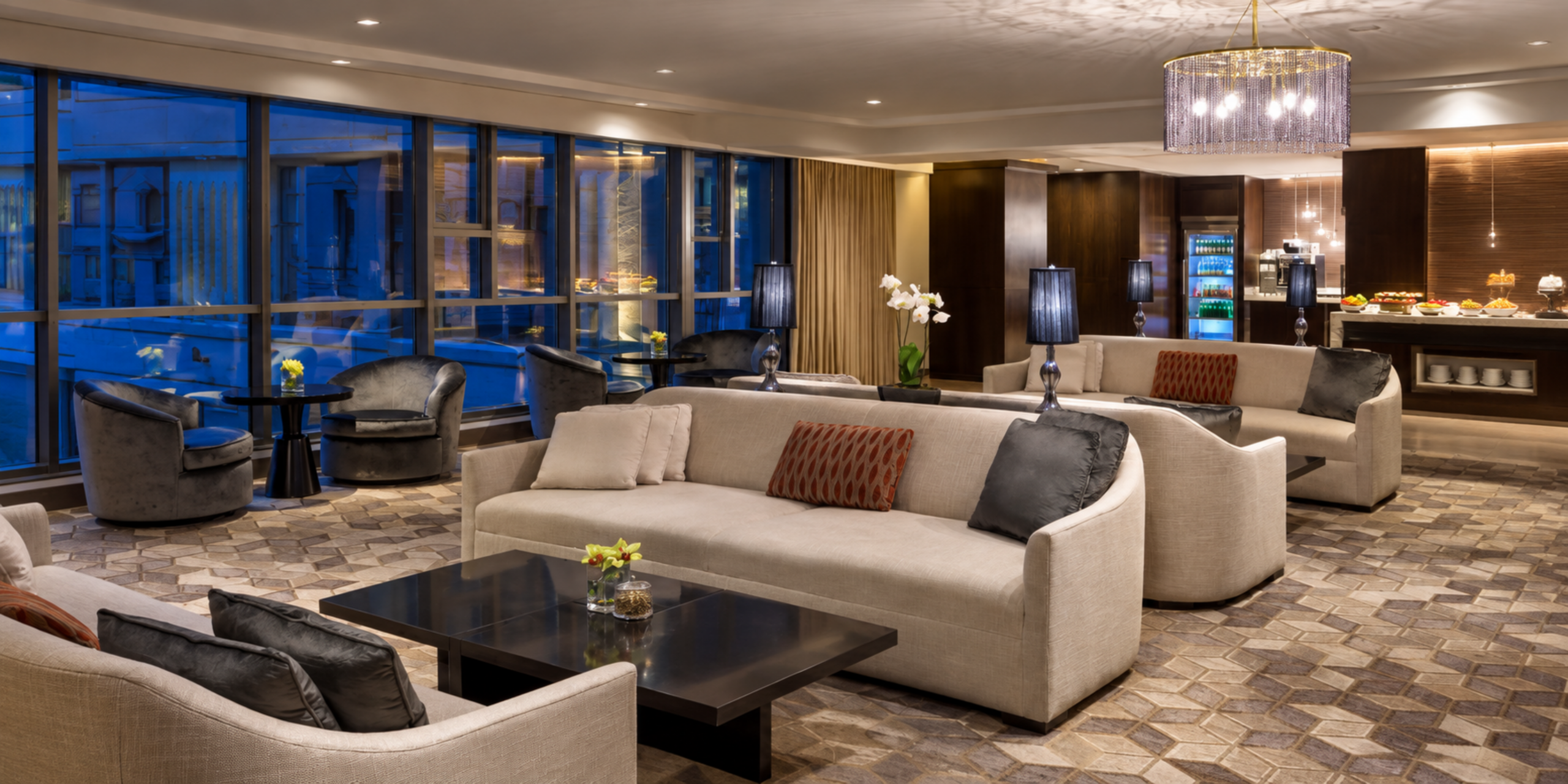 Salon exécutif luxueux du Jabal Omar Hyatt Regency Makkah avec canapés confortables et grandes baies vitrées, illustrant les offres exclusives et l'accompagnement sur-mesure de Direct Mecca pour votre séjour.